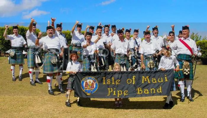 The band in kilts behind an Isle of Maui Pipe Band banner