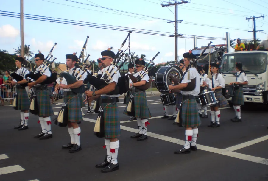 The band marching down a street in kilts