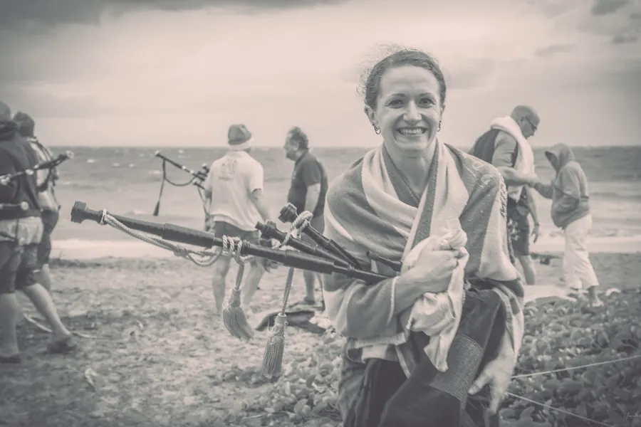 Black and white photo of a smiling woman wrapped in a towel after the plunge
