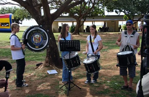 Drummers practicing under a tree