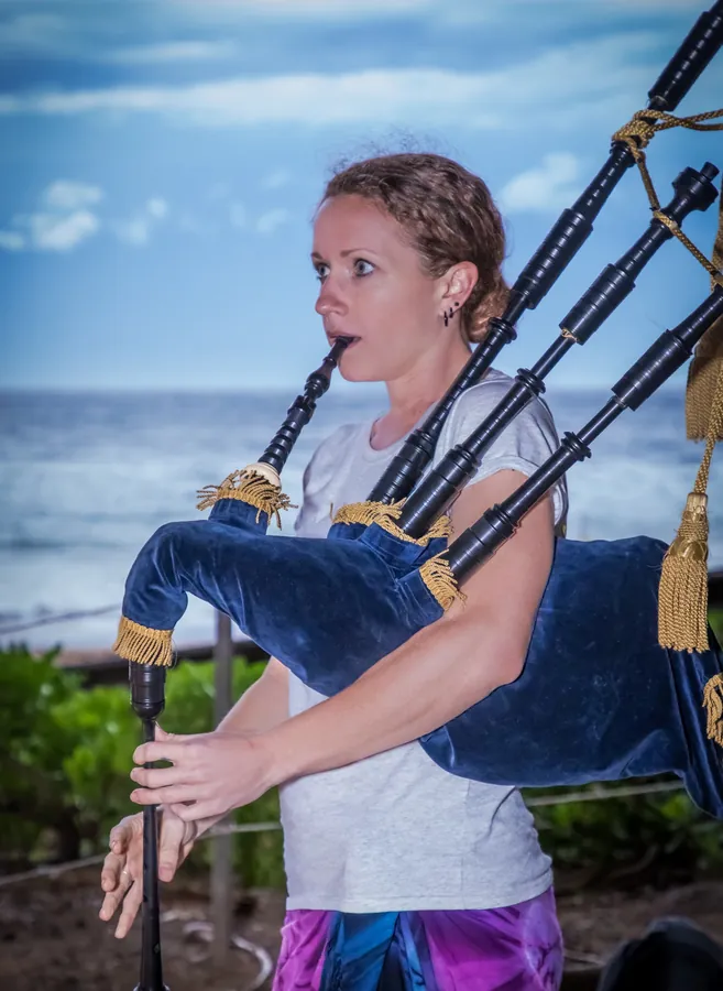 A young piper playing by the ocean
