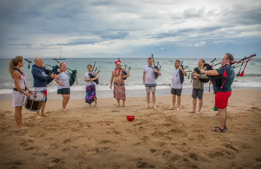 Pipers and drummers playing in a line on the sand