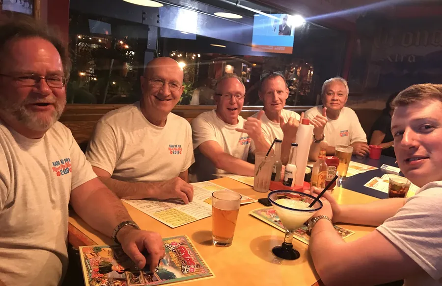 Friends grinning around a restaurant table