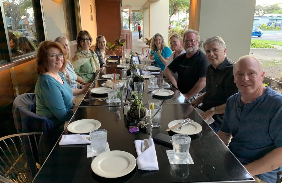A long dinner table of smiling students