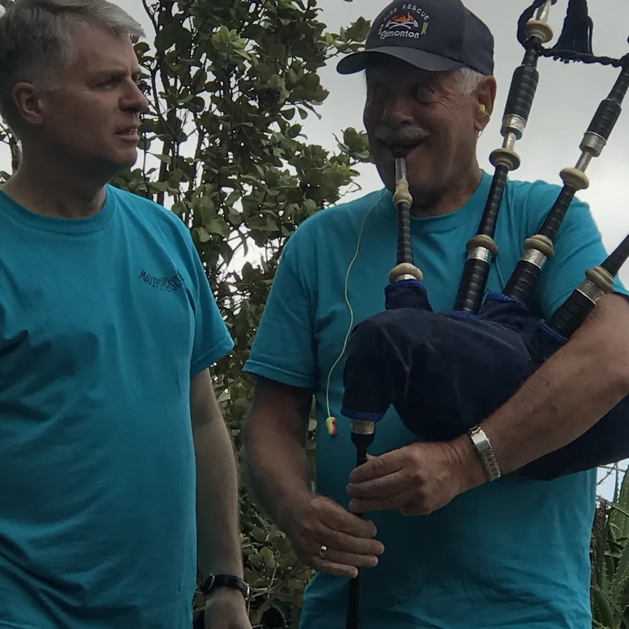 An instructor playing pipes with a student